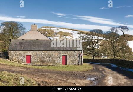 Eine alte Scheune, wahrscheinlich aus Stein gebaut, der vor Jahrhunderten von der nahe gelegenen Hadrianmauer ausgeraubt wurde, verbunden mit dem Bauernhof in Walltown, Northumberland, Großbritannien Stockfoto