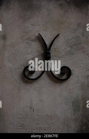 Kunstvolle Metall-Krawatte Bar auf Steinwand, Unterstützung für Wand, fontaine de vaucluce provence, frankreich; Stockfoto