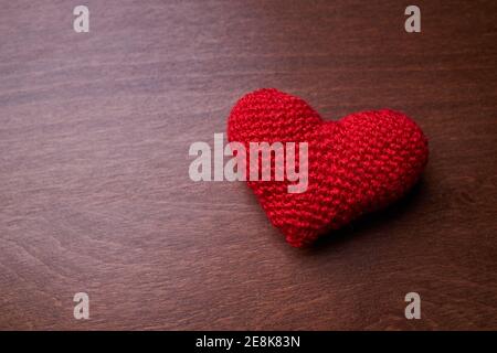 Rotes Herz-Symbol auf einem dunklen Holzhintergrund. Kopierraum. Romantik und valentinstag-Konzept Stockfoto