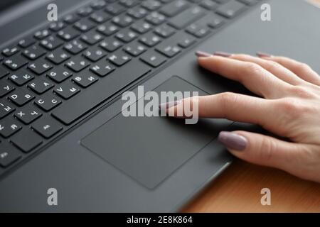 Weiblich mit schwarzem Laptop für die Arbeit. Surfen im Internet mit Touchpad. Business-Konzept Stockfoto