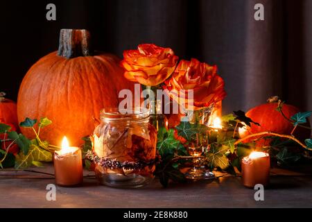Herbsthochzeit Dekoration mit Kürbissen, Orangenrosen und Kerzen. Partydekor Stockfoto