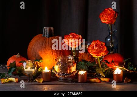 Herbsthochzeit Dekoration mit Kürbissen, Orangenrosen und Kerzen. Partydekor Stockfoto