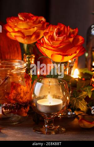 Herbsthochzeit Dekoration mit Kürbissen, Orangenrosen und Kerzen. Partydekor Stockfoto