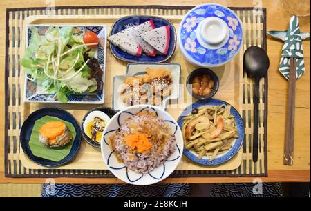 Blick von oben auf das japanische Frühstück (frisches Gemüse, Natto, Reis, Karaage-Huhn, gebratene Pilze, gekochte Eier Stockfoto