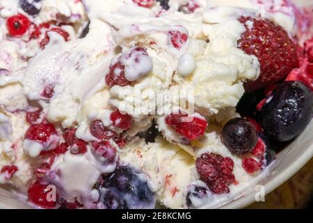 Nahaufnahme von Vanilleeis mit blauen Beeren, roten Johannisbeeren und Himbeeren Stockfoto