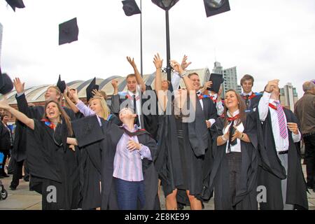 Kürzlich graduierte Studenten werfen ihre Mörtel Board Hüte In der Luft, um ihre Grad zu feiern Stockfoto