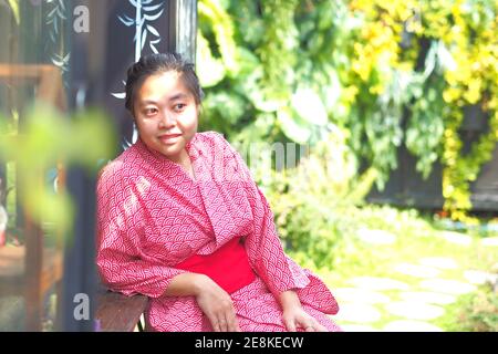 Weicher Fokus auf asiatische Frau trägt Kimono oder Yukata im japanischen Stil Garten. Stockfoto