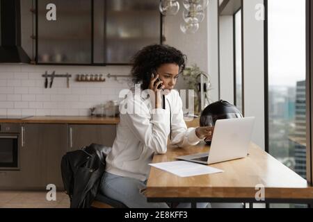 Afrikanische Frau sprechen per Telefon diskutieren Vorschlag auf Laptop-Bildschirm Stockfoto