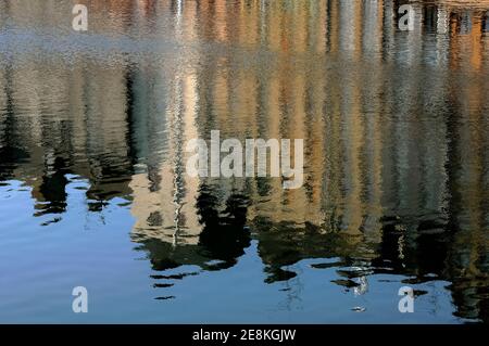 Hohe, schmale Häuser aus dem 17. Und 18. Jahrhundert säumen den beliebten und malerischen Quai Sainte Catherine spiegeln sich im Vieux Bassin (Old Basin oder Dock), dem Mittelpunkt des historischen Honfleur, Calvados, Normandie, Frankreich, während eine Januarbrise das ruhige Wasser rauscht. Der Hafen wurde in den 1680er Jahren gegründet und ist eines einer Reihe von Becken, die durch einen Zugangskanal mit der seine verbunden sind. Stockfoto