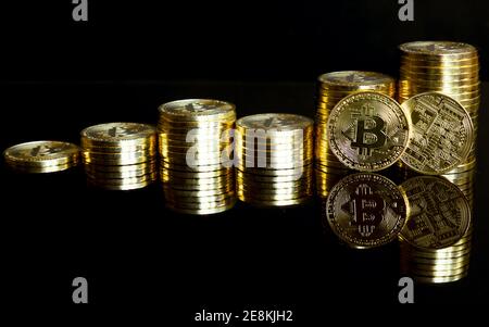 Goldene Bitcoins als Diagramm gestapelt. Mit Reflexion auf schwarzem Hintergrund. Stockfoto