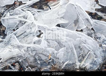 Eiskristalle wachsen über einen kleinen Strom bilden gerade und Krümmungsmuster Stockfoto