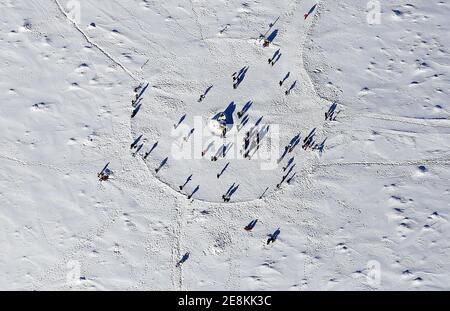 Brocken, Deutschland. Januar 2021. Ausflügler stehen im Schnee auf dem Gipfel des Brockens im Oberharz. Weil es sonnig ist, werfen die Menschen lange Schatten auf die Schneedecke auf dem Berg. (Luftaufnahme aus einem Flugzeug). Quelle: Stefan Rampfel/dpa/Alamy Live News Stockfoto