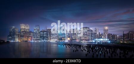 Die Skyline von New York City bei Nacht fotografiert von der anderen Seite des East River im Brooklyn Bridge Park. Stockfoto