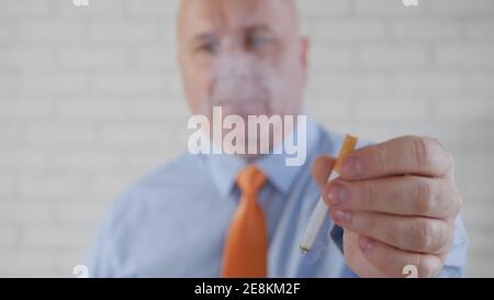 Bild mit einem Geschäftsmann, der eine Zigarette raucht. Rauch und Nikotin sucht verursacht ernste Gesundheitsprobleme. Stockfoto