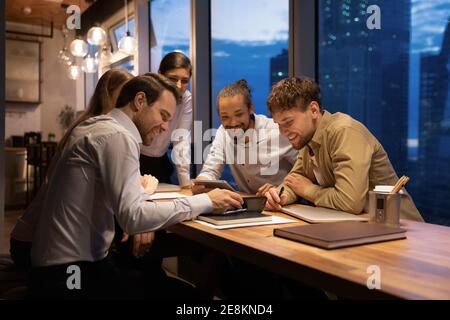 Eine Gruppe von fünf verschiedenen Kollegen hat viel Spaß beim Meeting Room Stockfoto