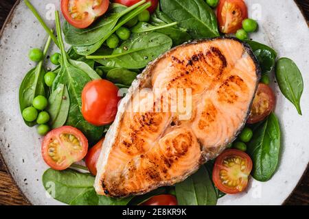 Geröstetes Lachssteak mit Gemüse und Kirschtomaten. Gesundes Abendessen oder Mittagessen Stockfoto