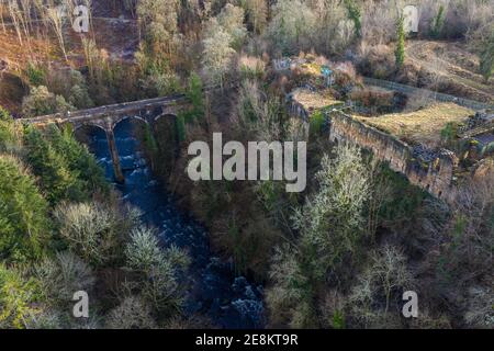 Hamilton, Schottland, Großbritannien. Januar 2021. Im Bild: Luftdrohnenfotografie mit Cadzow Castle und der gewölbten Brücke über das Avon-Wasser, die sich durch die steile Schlucht im Chatelherault Country Park schlängelt. Die Sonne ist draußen und die Menschen genießen sich während der Coronavirus Phase 4 Lockdown. Die Temperaturen liegen bei etwa 2 Grad, wobei die Temperaturen voraussichtlich über Nacht wieder fallen werden, bei einigen eisigen Bedingungen. Ruhig und sehr sonnig mit blauem Himmel. Quelle: Colin Fisher/Alamy Live News Stockfoto