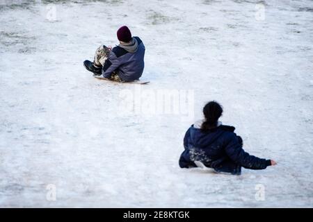 Berlin, Deutschland. Januar 2021. Deutschland, Berlin, 31. Januar 2021: Jugendliche fahren auf behelfsmäßigen Schlitten, während Menschen und Familien das Wochenende im Viktoriapark in Kreuzberg genießen, trotz der Kontaktbeschränkungen aufgrund der anhaltenden globalen Covid-19-Pandemie. Die Berliner sind dringend gefordert, den körperlichen sozialen Kontakt mit Menschen von außerhalb des Hauses auf das absolute Minimum zu reduzieren. Menschen dürfen ihr Zuhause nur aus wichtigen Gründen verlassen. (Foto: Jan Scheunert/Sipa USA) Quelle: SIPA USA/Alamy Live News Stockfoto