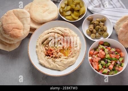 Klassischer Hummus mit Olivenöl auf dem Teller und Pita-Brot. Stockfoto