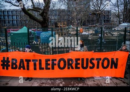 London, Großbritannien. Januar 2021. Unterstützer kommen mit einem Banner mit der Aufschrift "STOP HS2 Now, #BattleforEuston" an - das Lager gegen das Aussterben von HS2 wird weiterhin von Gerichtsvollzieher (vom National Enforcement Team, NET, einer Tochtergesellschaft der High Court Enforcement Group) auf der Euston Station geräumt (um einen temporären Parkplatz zu schaffen). Alle oben genannten Demonstranten wurden geräumt, und es scheint nun eine Pause zu geben, bevor die Tunnel behandelt werden. Kredit: Guy Bell/Alamy Live Nachrichten Stockfoto