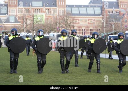 Amsterdam, Niederlande. Januar 2021. Holländische Anti-Riot-Polizeibeamte treten während einer illegalen Anti-Sperrdemonstration am Museumplein inmitten der Coronavirus-Pandemie am 31. Januar 2021 in Amsterdam, Niederlande, gegen Demonstranten vor.die Amsterdamer Bürgermeisterin Femke Halsema klassifizierte den Museumplein als "Sicherheitsrisikogebiet", Polizeibeamten das Recht zu geben, jeden in diesem Gebiet zu überprüfen und zu durchsuchen, um illegale Demonstrationen und Vandalismus zu verhindern. (Foto von Paulo Amorim/Sipa USA) Quelle: SIPA USA/Alamy Live News Stockfoto