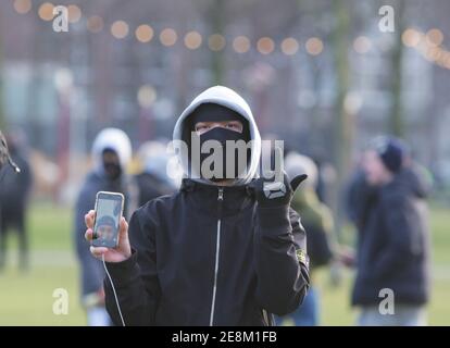 Amsterdam, Niederlande. Januar 2021. Ein Anti-Lockdown-Protestant hielt sein Handy und seine Geste während einer illegalen Anti-Lockdown-Demonstration am Museumplein inmitten der Coronavirus-Pandemie am 31. Januar 2021 in Amsterdam, Niederlande. Die Amsterdamer Bürgermeisterin Femke Halsema stufte den Museumplein als "Sicherheitsrisikogebiet" ein und gab Polizeibeamten das Recht, jeden in diesem Gebiet zu überprüfen und zu durchsuchen, um illegale Demonstrationen und Vandalismus zu verhindern. (Foto von Paulo Amorim/Sipa USA) Quelle: SIPA USA/Alamy Live News Stockfoto