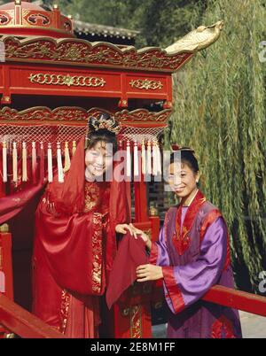 Asien, China, Peking, traditionelle Hochzeitszeremonie, Frauen in Tracht gekleidet Stockfoto