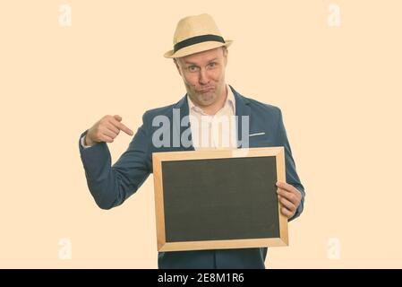 Studio shot reifer Geschäftsmann Holding leere Tafel und Zeigefinger Stockfoto