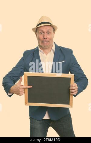 Reifen Geschäftsmann Holding leere Tafel während Zeigefinger Schockiert Stockfoto