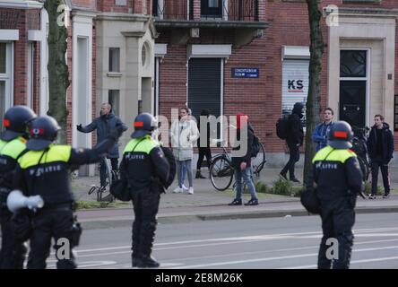 Amsterdam, Niederlande. Januar 2021. Anti-Lockdown-Demonstranten reagieren gegen holländische Anti-Riot-Polizisten auf der Straße während einer illegalen Demonstration in der Nähe des Museumplein inmitten der Coronavirus-Pandemie am 31. Januar 2021 in Amsterdam, Niederlande.die Amsterdamer Bürgermeisterin Femke Halsema klassifizierte den Museumplein als "Sicherheitsrisikogebiet", Polizeibeamten das Recht zu geben, jeden in diesem Gebiet zu überprüfen und zu durchsuchen, um illegale Demonstrationen und Vandalismus zu verhindern. (Foto von Paulo Amorim/Sipa USA) Quelle: SIPA USA/Alamy Live News Stockfoto