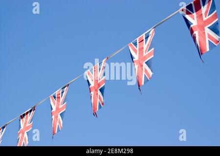 Bunting, das aus der Unionsflagge des Vereinigten Königreichs besteht, die gegen einen blauen Himmel fliegt. Stockfoto