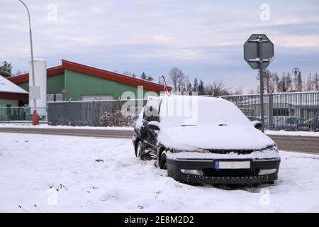 Verlassene Auto im Graben nach dem Verkehrsunfall. n´t Fahrer gab dem anderen Auto nicht nach. Von Schnee bedeckt. Stockfoto