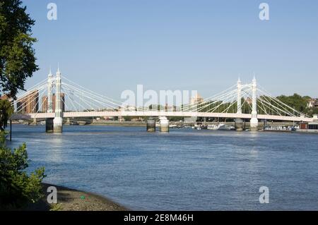 Blick auf die prunkvolle Albert Bridge, die die Themse zwischen Battersea und Chelsea in London überspannt. Blick vom öffentlichen Fußweg, Battersea. Stockfoto