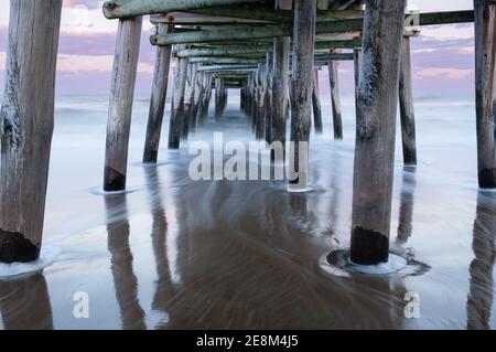 Der Sandbridge Fishing Pier in Virginia Beach bei Sonnenuntergang, mit langer Belichtung macht das Wasser seidig und verträumt Stockfoto