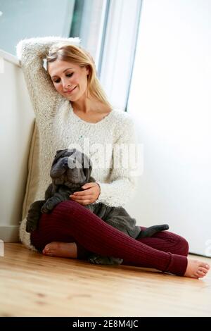 Schöne blonde Frau saß mit ihrem Hund Stockfoto