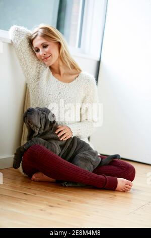 Schöne blonde Frau saß mit ihrem Hund Stockfoto