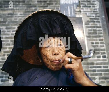 China, Hongkong, ältere Hakka Frau in traditionellen Kostüm Smoking Pipe gekleidet Stockfoto