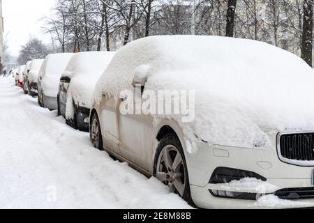 Schneebedeckte Autos oder Fahrzeuge auf der Straße geparkt Stockfoto