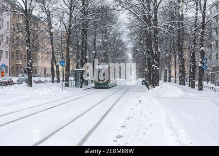 Tram 463 der Linie 4 an der Straßenbahnhaltestelle bei Schneefall im Munkkiniemi-Viertel von Helsinki, Finnland Stockfoto