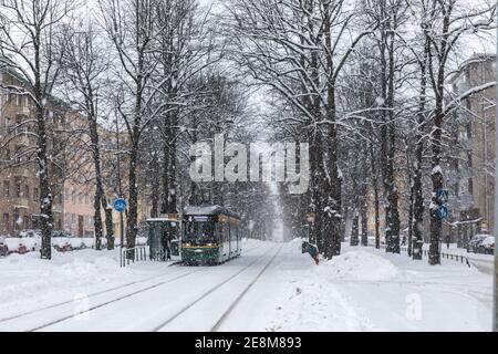 Tram 463 der Linie 4 bei Munkkiniemen puitstitie Haltestelle bei starkem Schneefall im Munkkiniemi Bezirk von Helsinki, Finnland Stockfoto