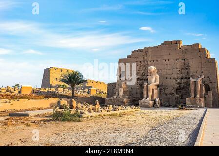 Beschädigte Sitzstatuen von Pharaonen an der Wand in Karnak Tempel Stockfoto