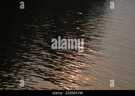 Sonnenuntergangssinnungen im Wasser erzeugen ein abstraktes Muster Stockfoto