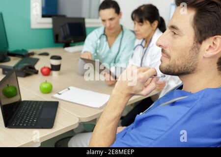 Arzt, der in Zusammenarbeit mit Ärzten über medizinische Probleme nachdenkt Stockfoto