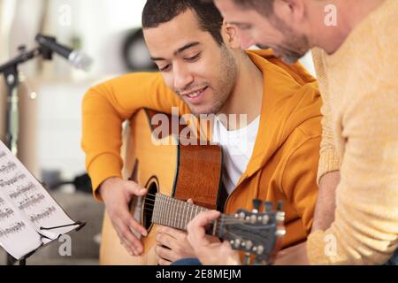 Gitarre Lehrer Lehre schönen jungen Mann Stockfoto