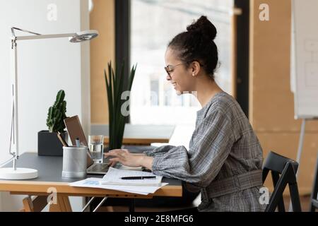 Glückliche junge afroamerikanische Büroangestellte trägt eine Brille Stockfoto