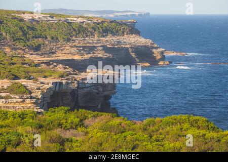 Felsige Küste und Heide im Royal National Park an einem sonnigen Sommertag in den östlichen Vororten von Sydney, NSW, Australien. Stockfoto