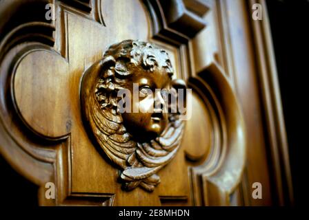 Engelsgesicht auf einer Holztür Stockfoto