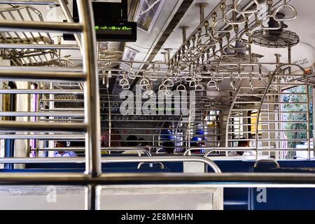 Mumbai, Maharashtra, Indien - Dezember, 2016: Innenansicht des lokalen Stadtzuges. Reihen von Stahlgeländern im leeren Bus mit Fans des lokalen Zuges. Stockfoto