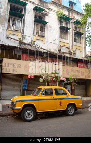 Kolkata, Indien - März, 2014: Oldtimer-Klassiker Ambassador-Taxi auf der Straße im historischen Viertel von Kalkutta. Gelbe Kabine vor CO geparkt Stockfoto