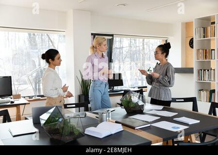 Gemischtes Führungsteam, das Arbeitsfragen im Meeting diskutiert Zimmer Stockfoto